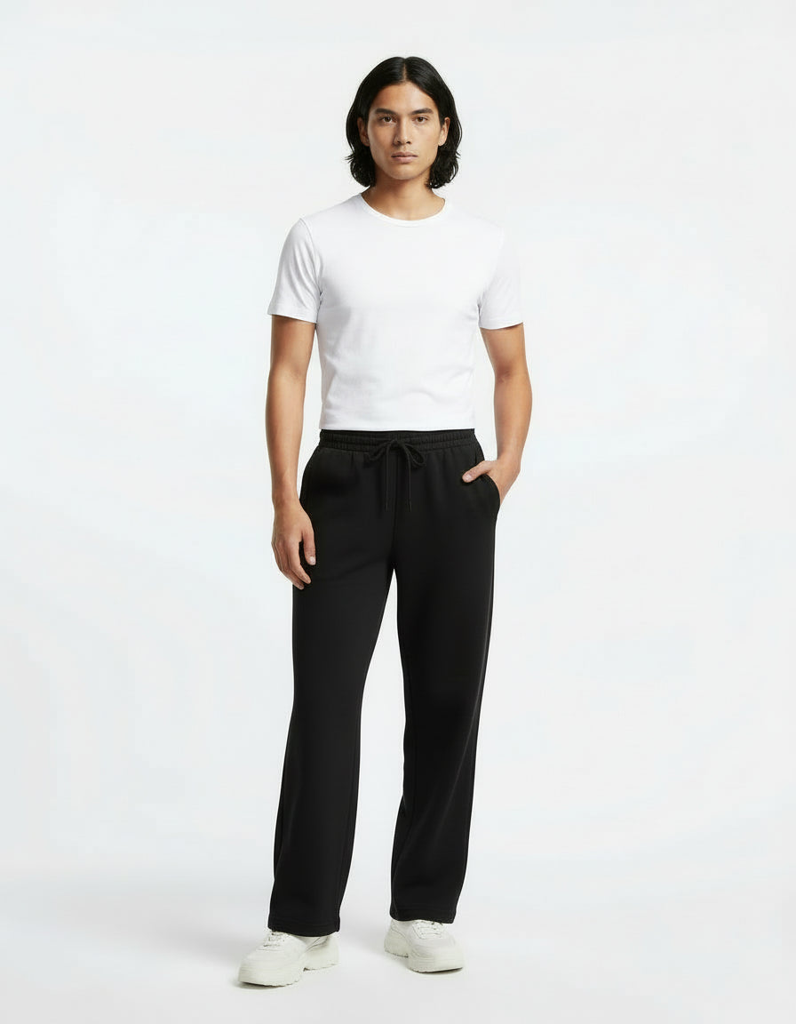 Woman wearing a gray long-sleeve top and black pants on a white background